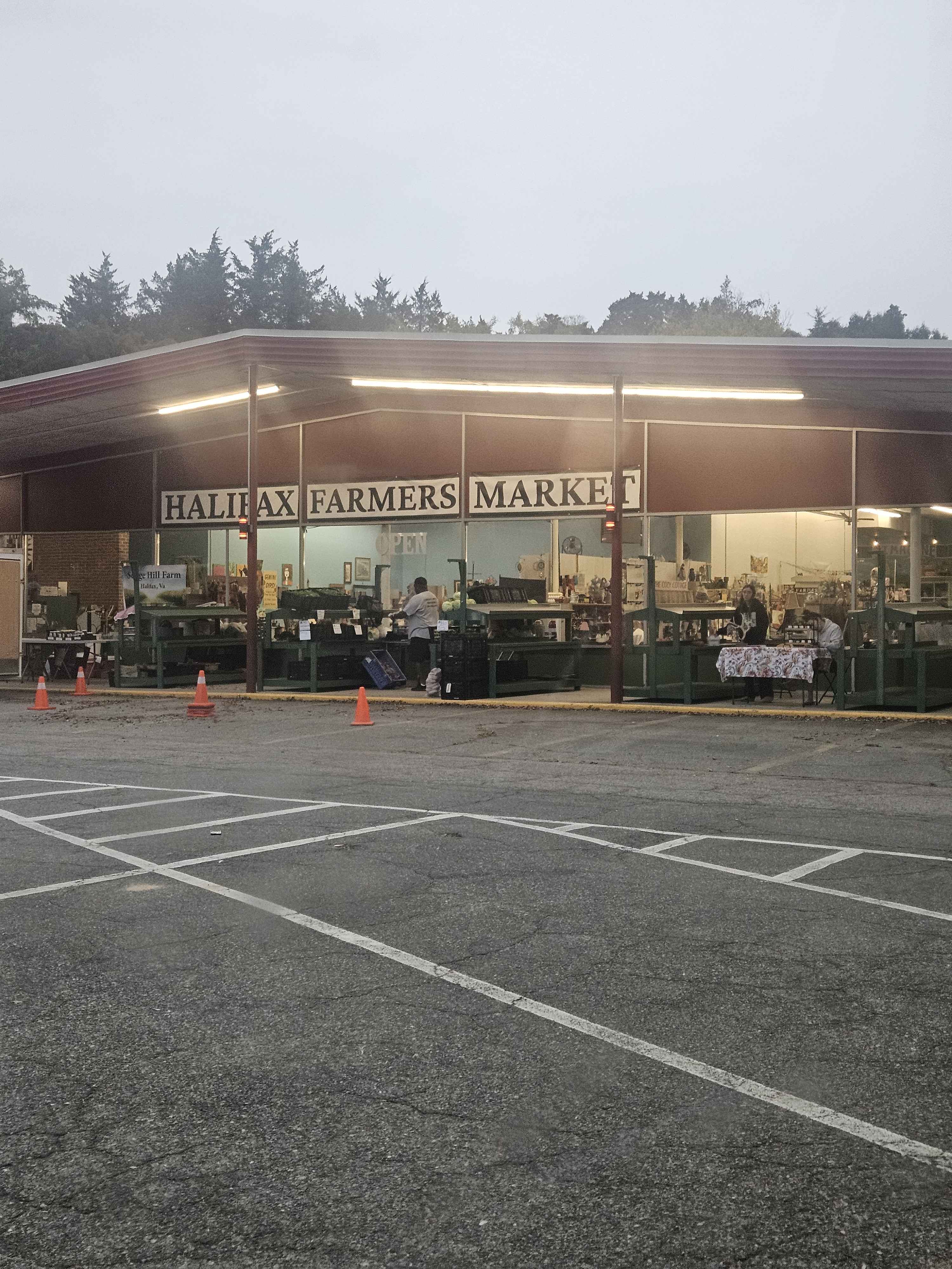 Halifax Farmers Market storefront on a rainy morning, with vendors under the awning and the sign visible across the front.